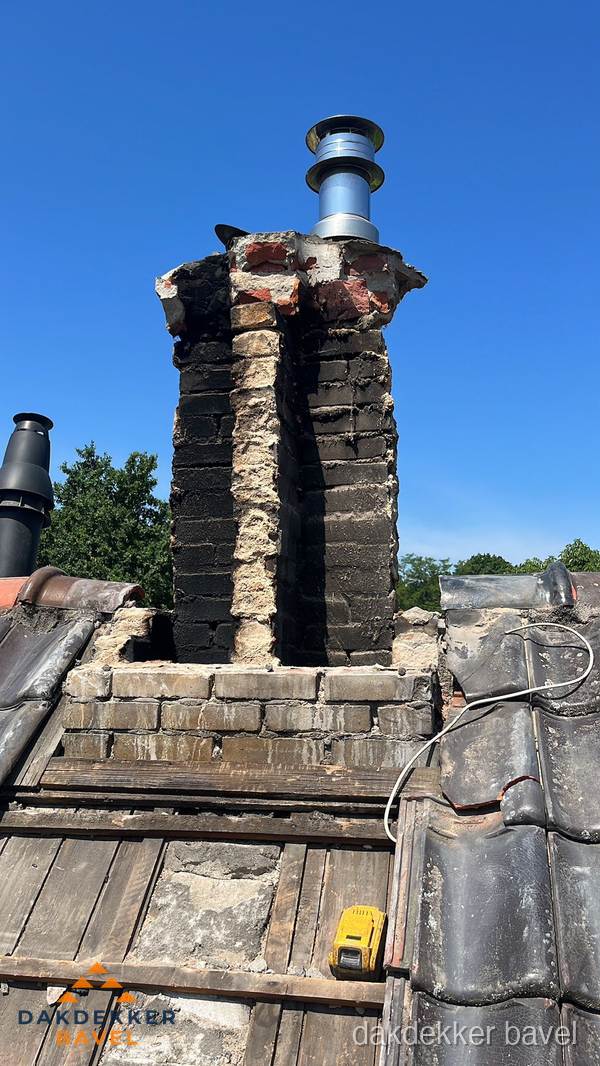 Beschadigde schoorsteen met nieuwe rookgasafvoer op oud dak in Bavel