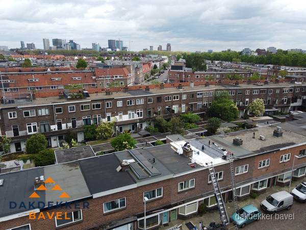 Spoed dakdekker aan het werk op plat dak in woonwijk Bavel