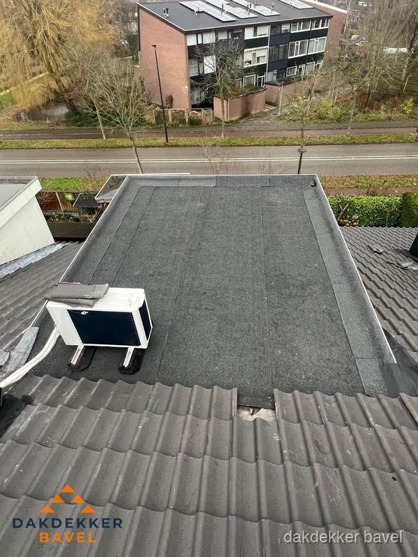 Plat dak inspectie met bitumen bedekking naast schuin pannendak in Bavel Plat dak inspectie met bitumen bedekking naast schuin pannendak in Bavel