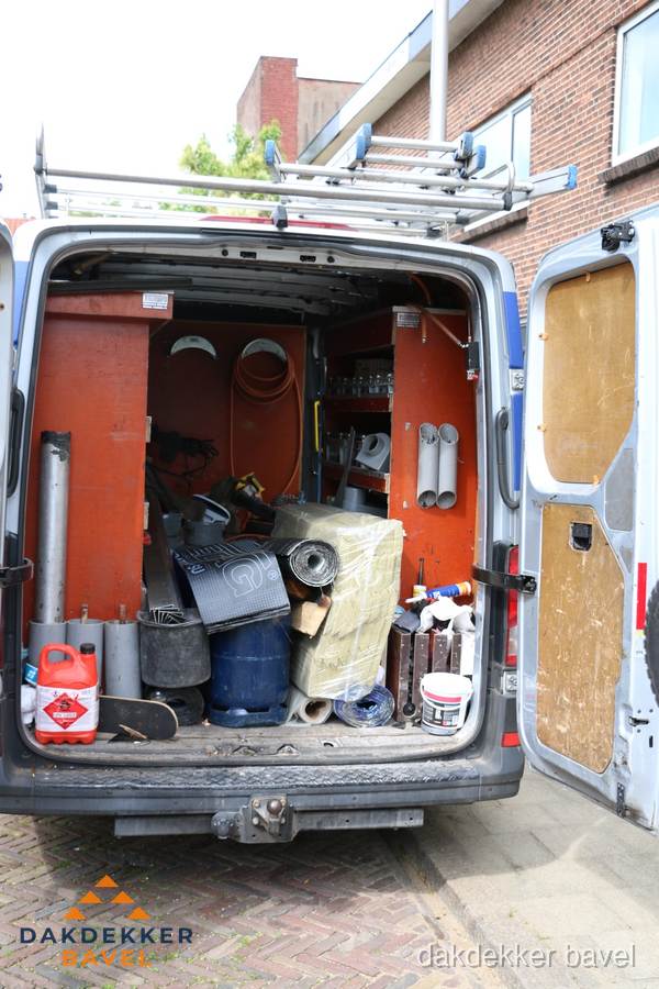 Bedrijfsbus van dakdekker met gereedschap en materialen in Bavel