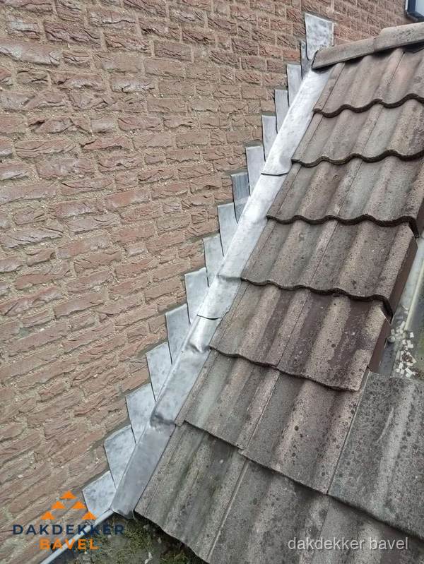 Loodslabben langs dakaansluiting bij bakstenen muur in Bavel
