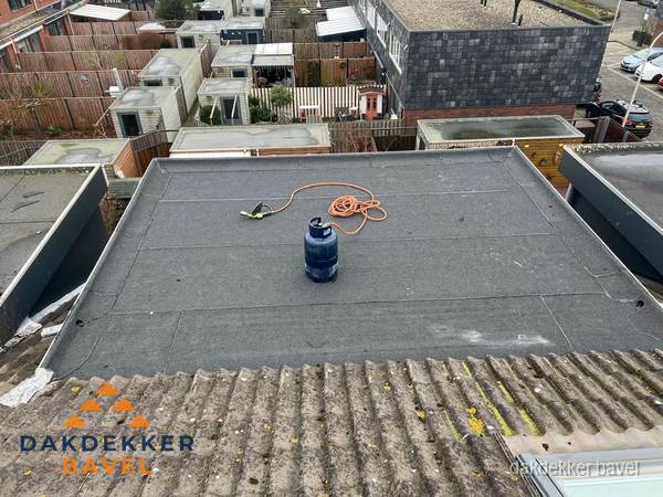 Plat dak met nieuwe bitumen dakbedekking en brandgereedschap in Bavel