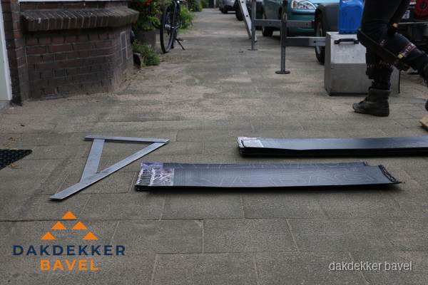 Dakbedekkingsmateriaal en zinkwerk klaargelegd voor reparatie in Bavel
